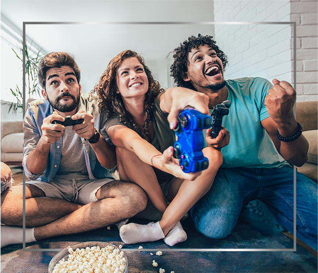 Group of young smiling people sitting on floor and playing video games, happy after Canespor fungal skin infection treatment