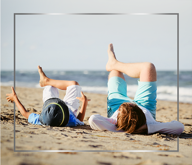 Mother and child lying on beach with crossed legs, happy after Canespor fungal skin infection treatment