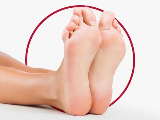 Clean and healthy female feet on white backdrop